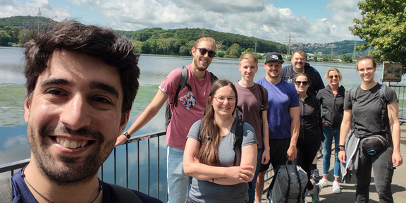 Eine Gruppe Menschen vor einem See.