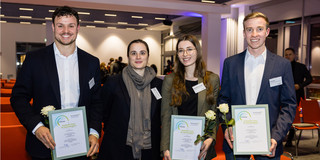 Vier Menschen lächeln in die Kamera