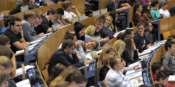 Students are sitting in a lecture in the audimax. 